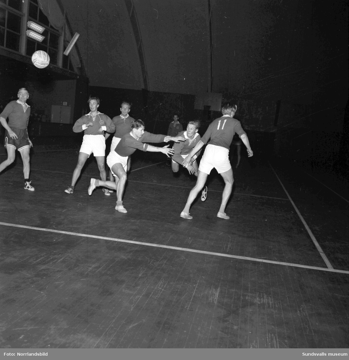 Handbollsmatch i tennishallen mellan elever och lärare.