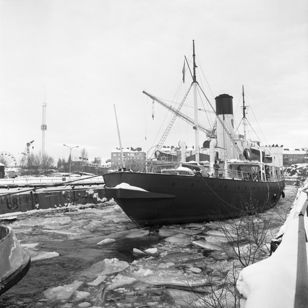 Isbrytaren Sankt Erik bogseras till dockan på Beckholmen under vintern 1987.