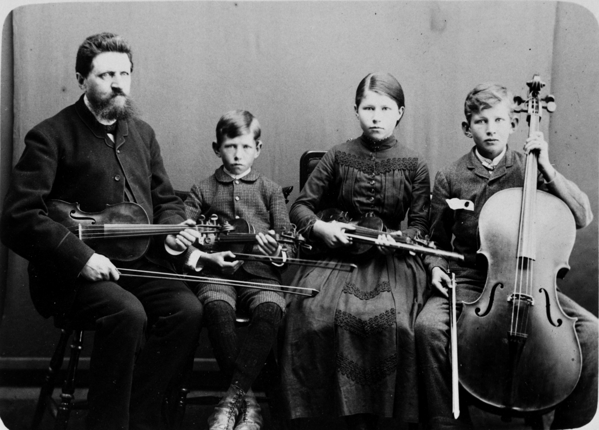 Tollef Nielsen Myklebye sammen med sine barn. 
Fra venstre: Tollef, Asbjørn, Ragnhild og Olav. Bilde er tatt ca 1887. Familieorkester. Musikkere. Musikk instrumenter