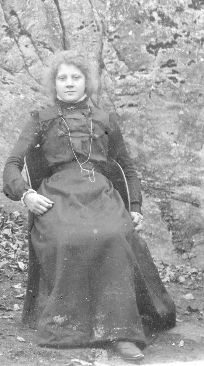 Selma Mørkvik, søster til Anders Mørkvik. Hun sitter ute i en kubbestol.