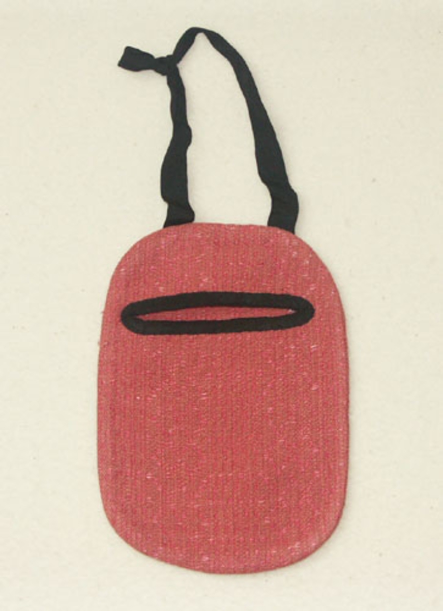 Kjolsäck till Sunnerbodräkt sydd i rosa daldrällstyg, sammat tyg har använts till  Sunnerbodräktens livstycken. Kjolsäckens öppning är kantad med svart ripsband, troligen av siden, som också använts till handtaget. På baksidan är en etikett från Kronobergs hemslöjd Växjö fastsydd.Kjolsäcken har använts till uthyrning.