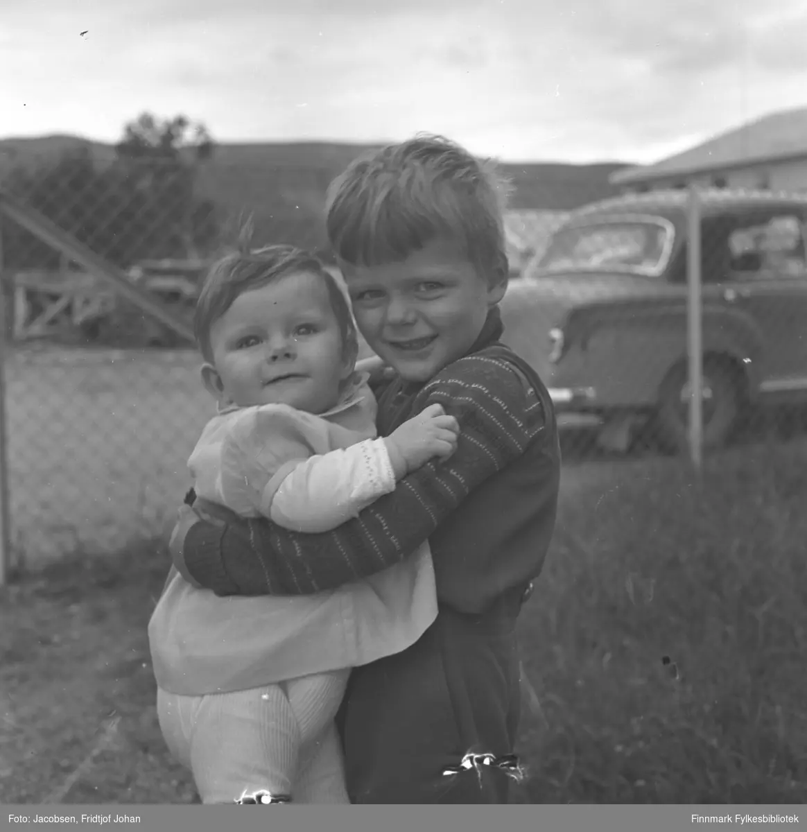 En liten gutt holder søsteren sin i hagen i Anton Tchudisvei i Oslo. De er Fossums barn, fornavn er ukjent.