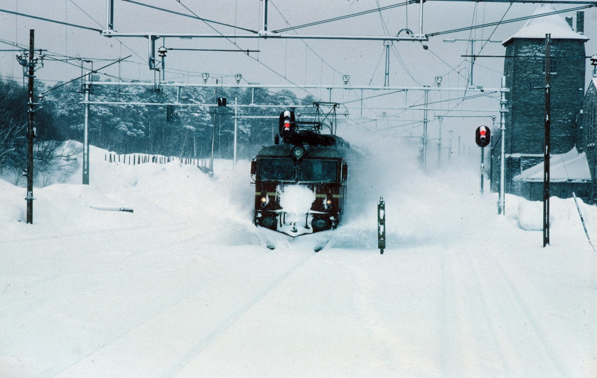 Ekspresstog 42 "Dovreekspressen" med lokomotiv NSB type El 14 kjører inn på Oppdal stasjon. Bildet er tatt fra lokomotivet i nordgående kistog Hjerkinn - Marienborg.