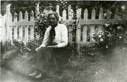 Ukjent kvinne foran stakittgjerde