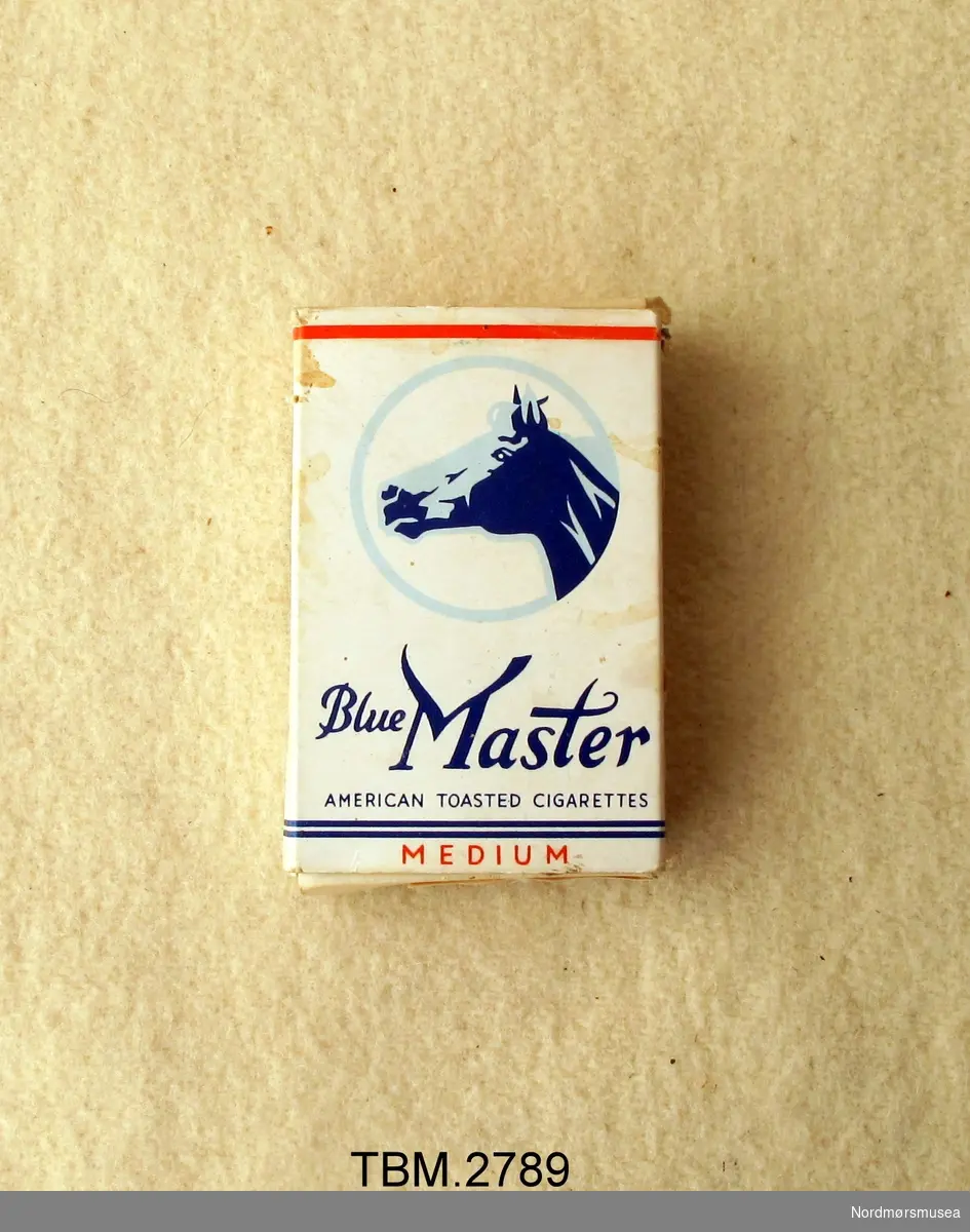Kvit sigaretteske med bilete av eit hestehovud i ein blå sirkel.
Eska er tom.