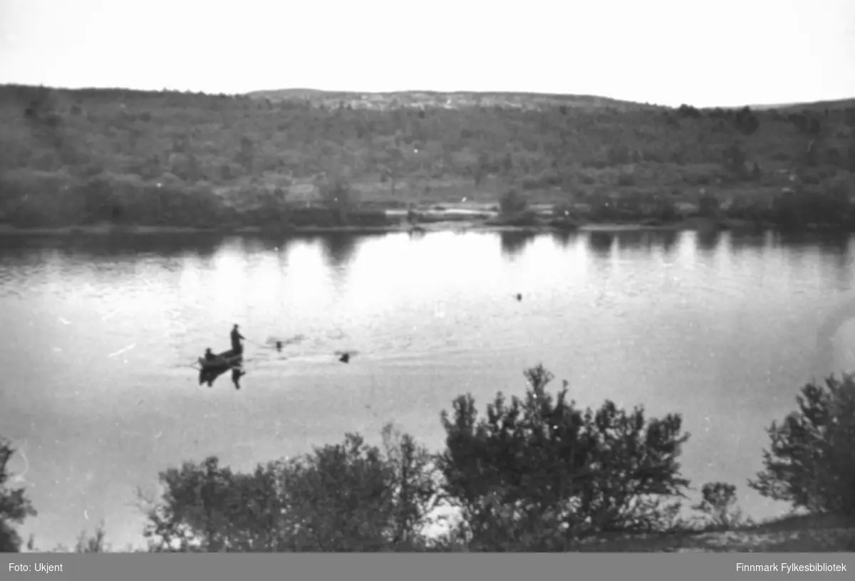 Fiske fra elvebåt i Pasvikelva. På baksiden av bildet er det for skrevet 'Grensefoss, Pasvik, 10.08.1939'.