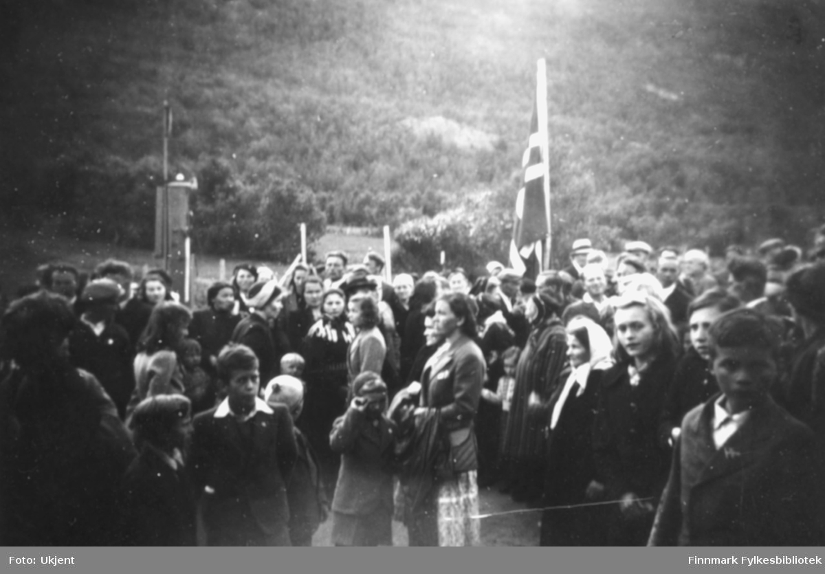 Fotografert under kong Haakons besøk i Tana 12.juli 1946. "Mye folk var møtt frem for å ta imot Kongen." Foto: ukjent. Bak fotografiet er det skrevet "Langnes".