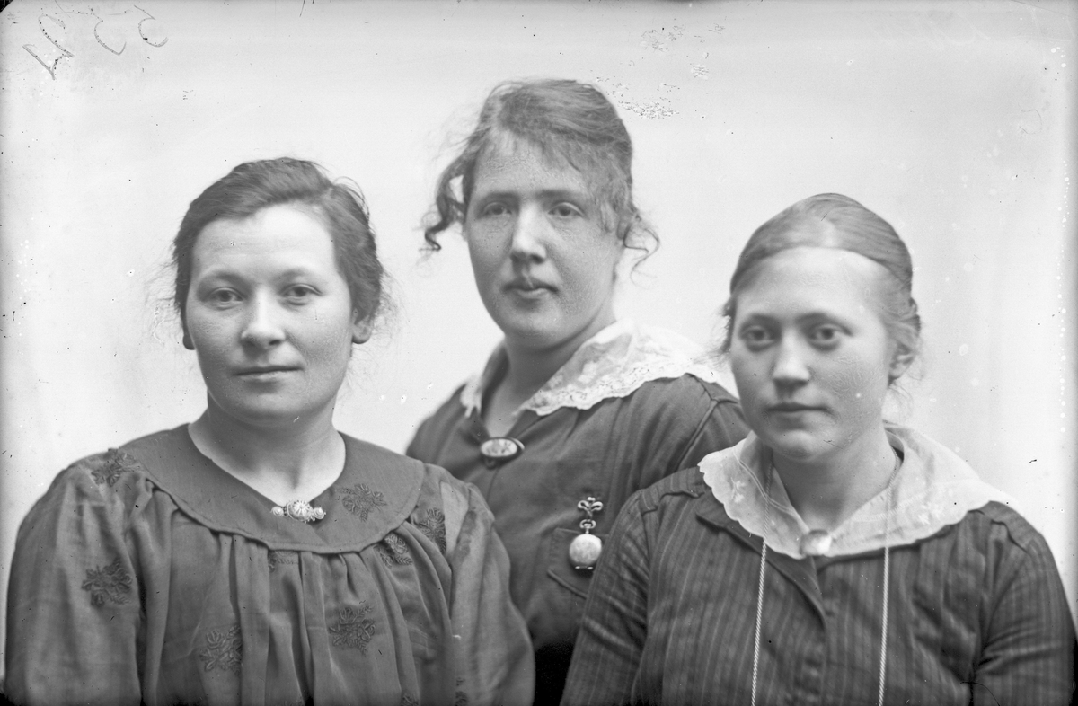 Gruppebilde av tre unge kvinner. Den ene er Anna Ørstrøm.