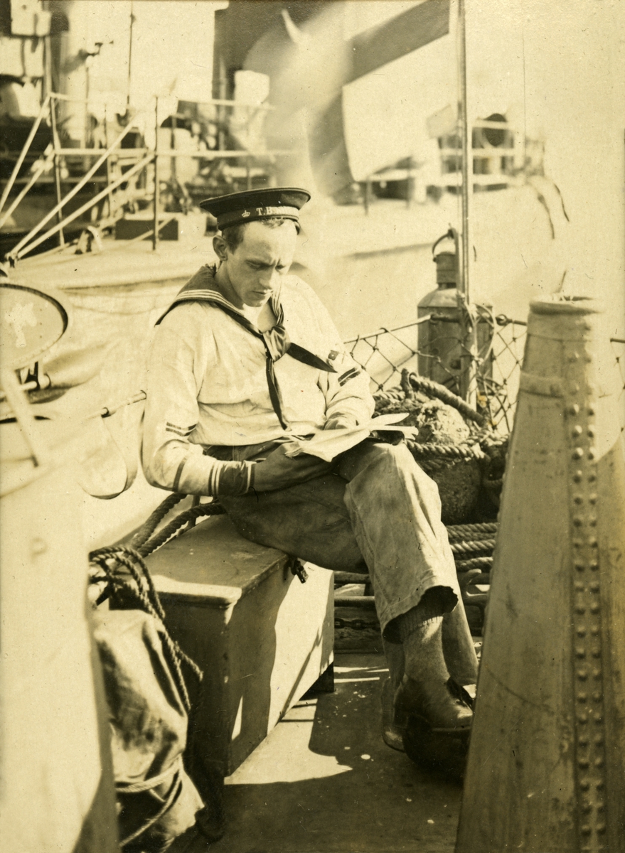 En sjöman sitter och läser ombord en torpedbåt.