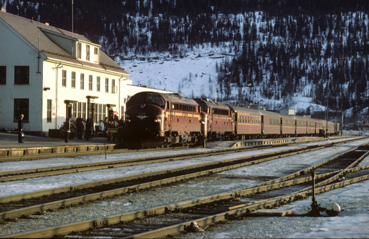 Dagtoget Trondheim - Bodø, tog 451, bremser inn på Mo i Rana stasjon. Toget trekkes av to diesellokomotiver type Di3 i fellesstyring med Di3 628 først. Vogner av type 3, og toget fører både 1. og 2. klasse samt kafeteriavogn.