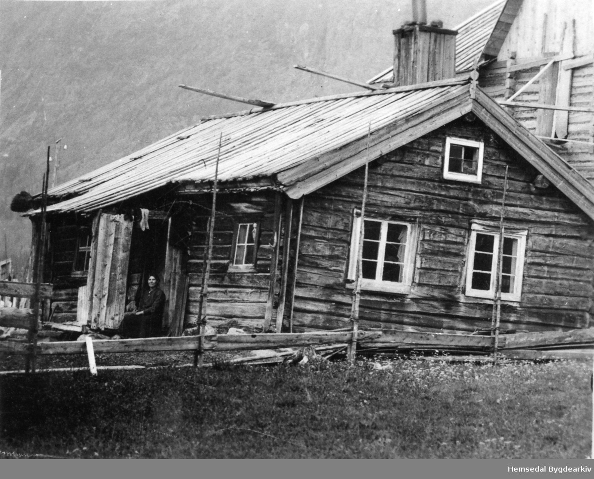 Gamlestova (Gamlestugo, dialekt)på garden Løken,59.1, i Hemsedal. Bak er bygnaden som vart sett opp i 1923. Anne Løken på trammen