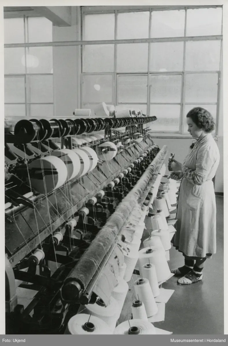 Ulike ledd i produksjonen ved Trengereid Fabrikker, truleg ca. 1950-52: kvinne ved spolemaskin.