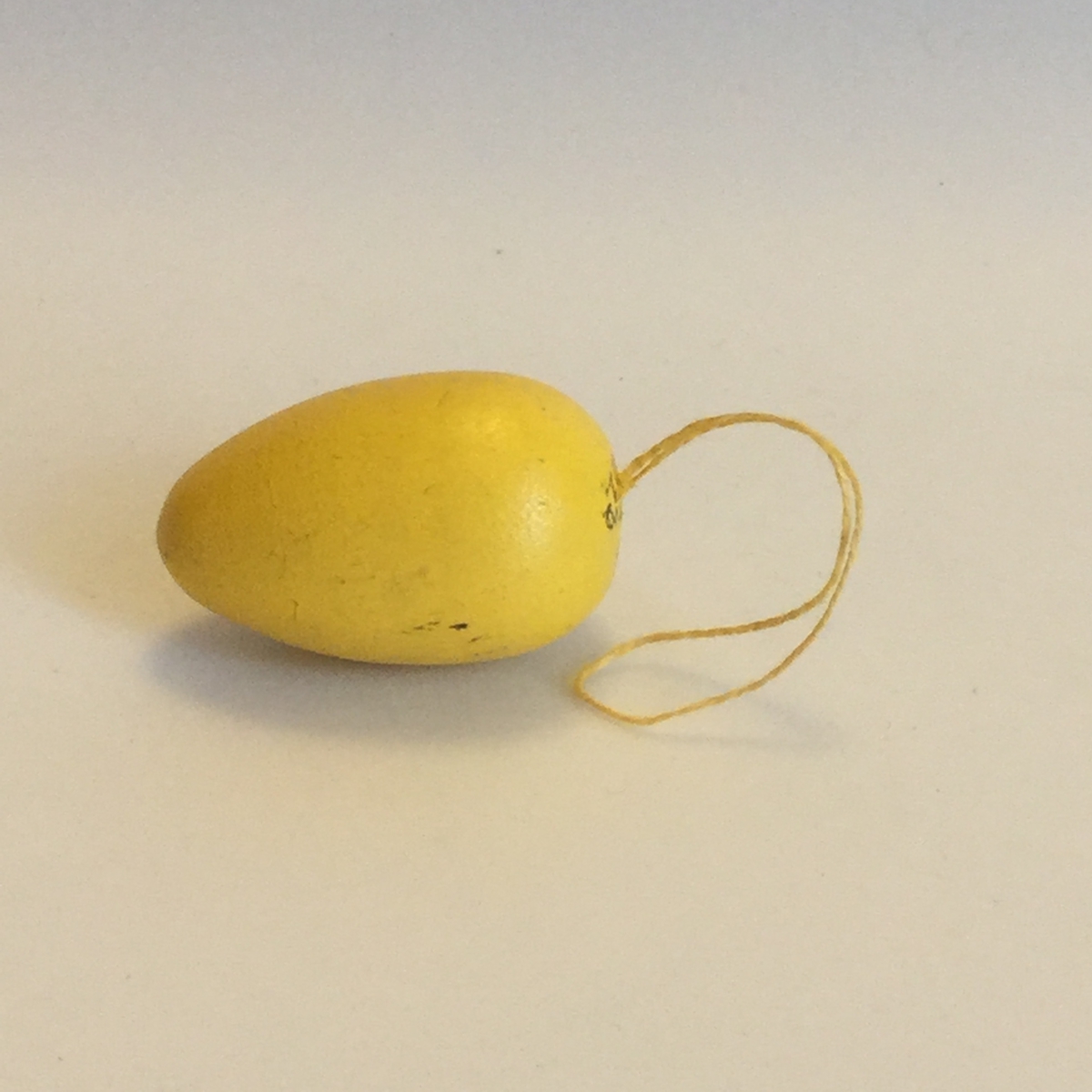 Prydnaden föreställer ett ägg.Ägget är svarvat i trä och målat i gult.Höjd 40 mm och bredd 25 mm