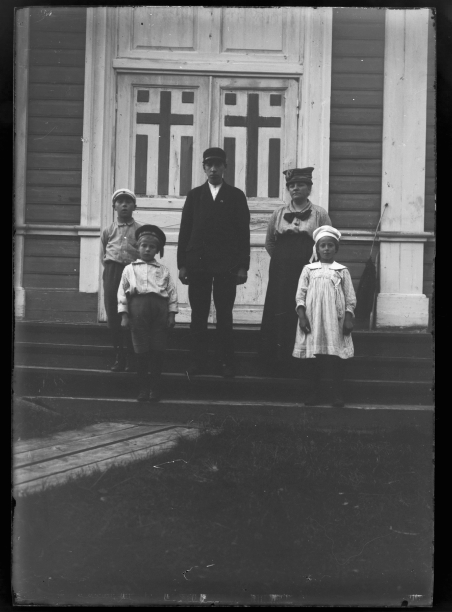 Boris Gleb. En mann, en kvinne og tre barn på kirketrappa, og vi ser den utsmykkete kirkedøra bak dem