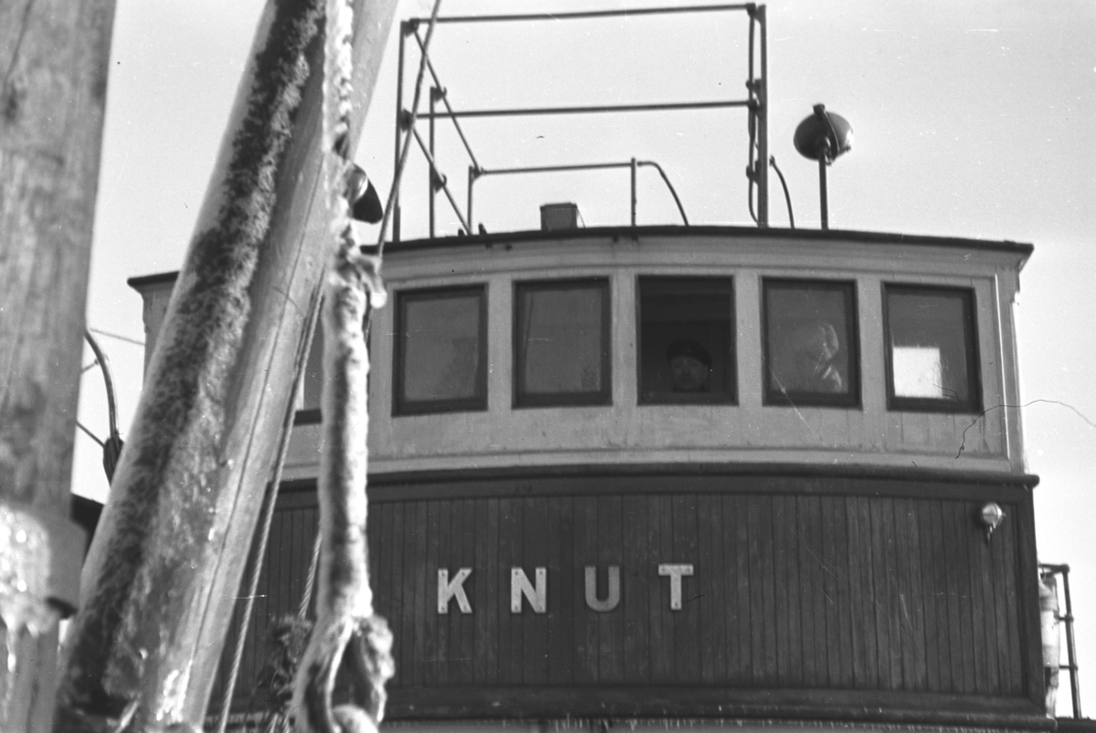 Rorhuset på skøyta "Knut" som også ble brukt som lokalbåt. Stedet og mannen i rorhusvinduet er utkjent.
