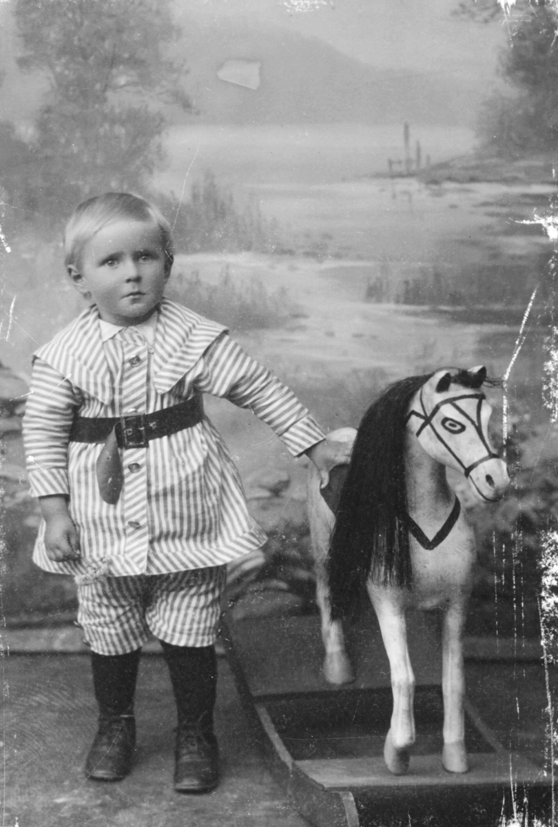 Portrett fra Godtfred Pedersen fotografet hos Emilie Henriksen. På bildet er han ca 2-3 år gammel.Ved siden av han står en gyngehest.