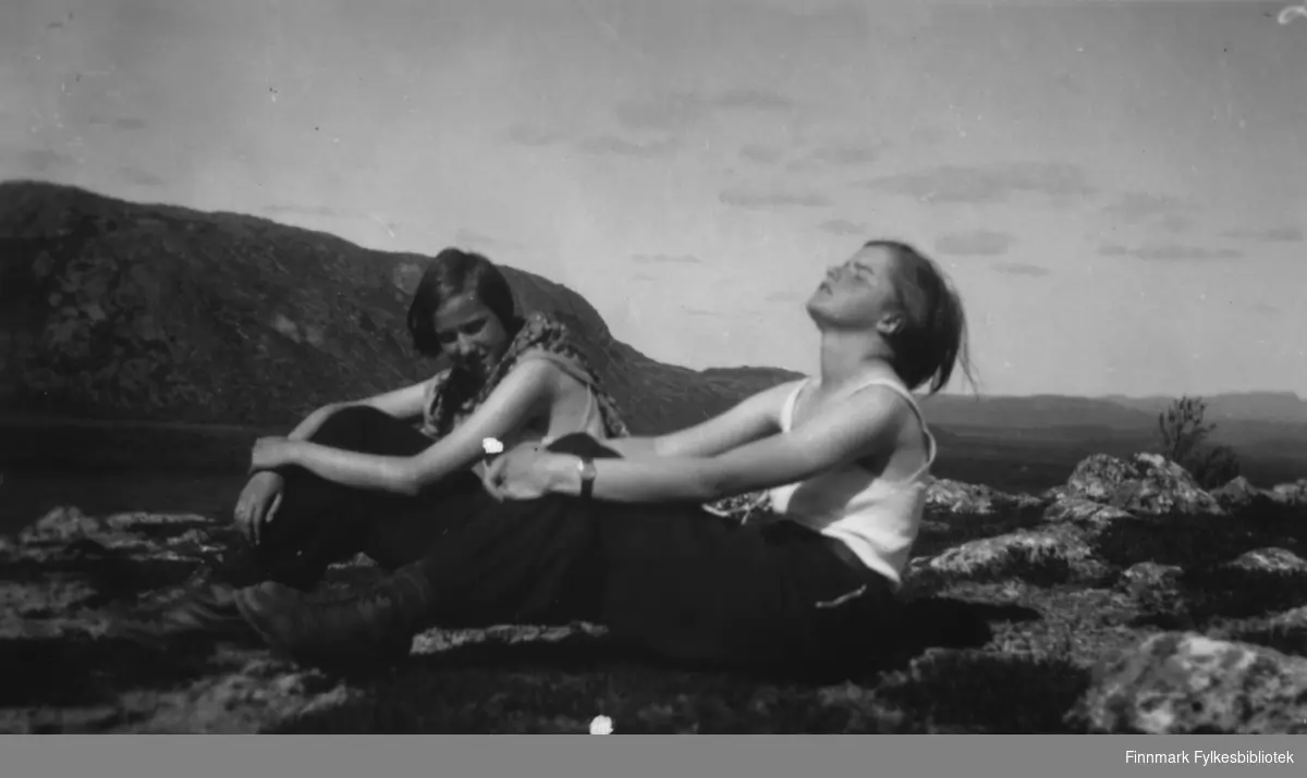 Ruth Grønvigh og Solveig Evanger nyter sommeren i Bugøyfjord. De har søkt litt opp i høyden der det var litt vind for å slippe unna myggen.
