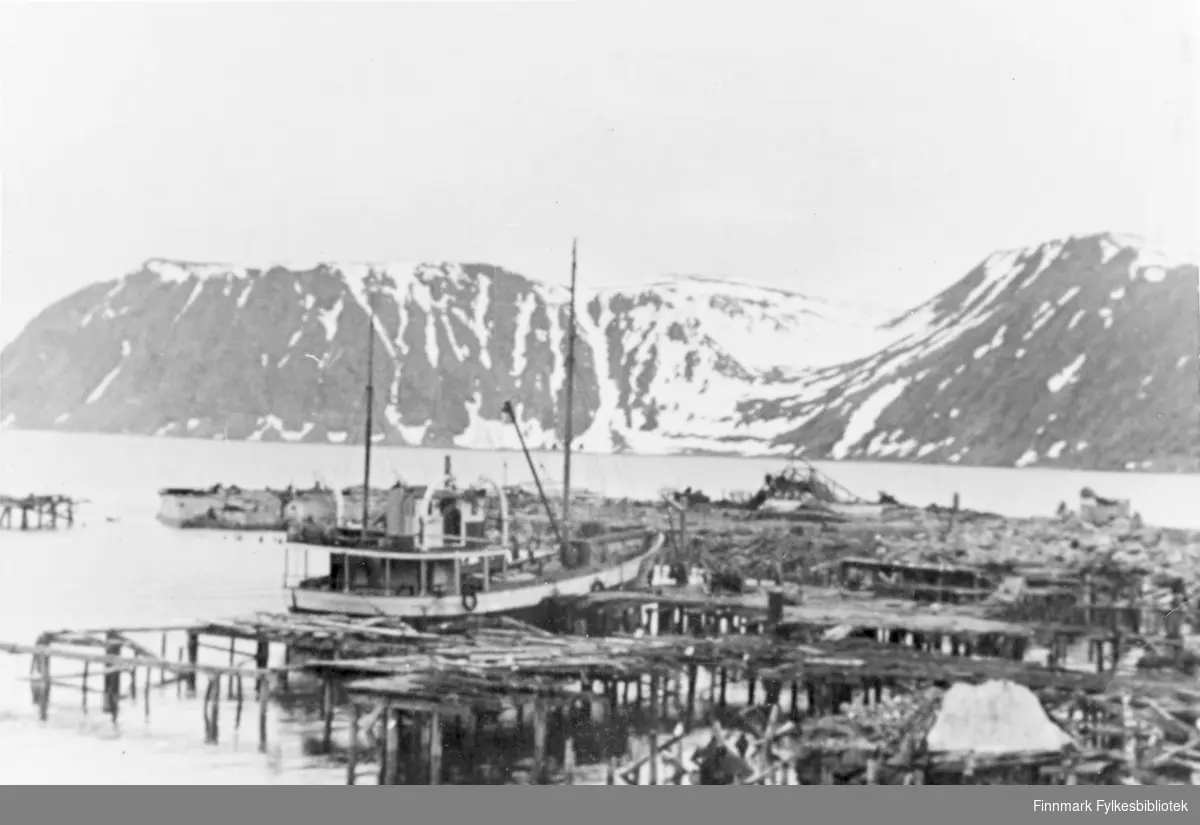 Bildet er fra havna i Honningsvåg. Vi ser ødelagte kaier og en båt.