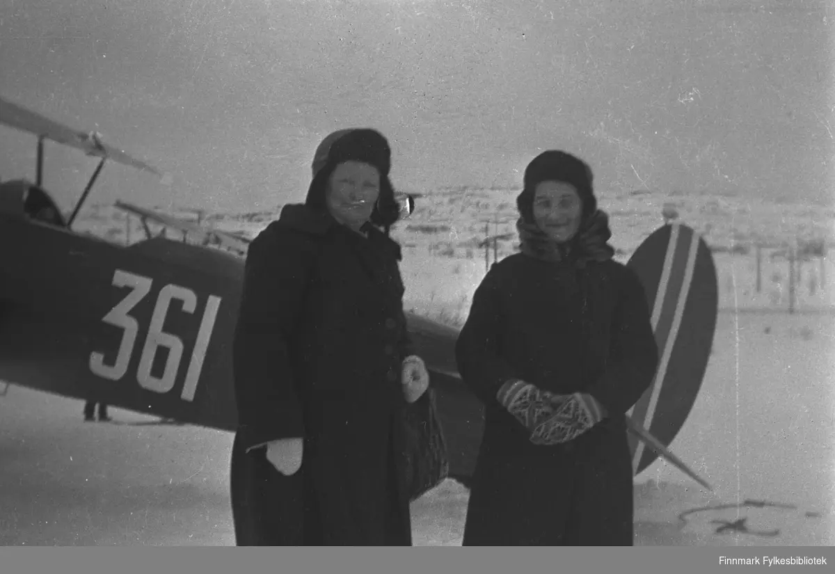 Svigerinnene Kathinka Mikkola og Valborg Nilsen på Førstevann under en flyoppvisning der, antakelig ca. 1935-1939. Flyet bak dem er en dobbeltdekker merket 361.