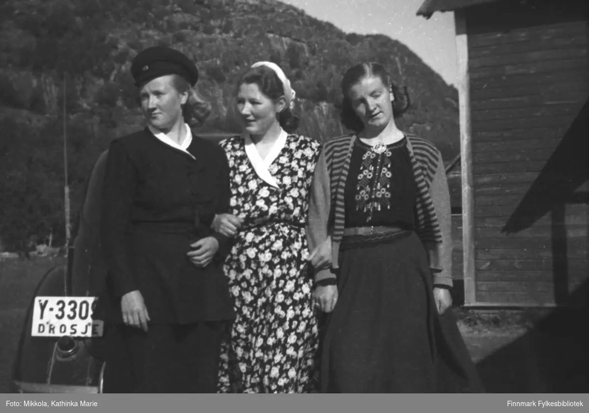 Tre av Mikkola-søstrene foran Karl Arvolas drosje (Y-3309?) utenfor Mikkelsnes. Fra venstre: Herlaug, Kari og Astrid. Herlaug har uniformslue, kanskje sjåførens?