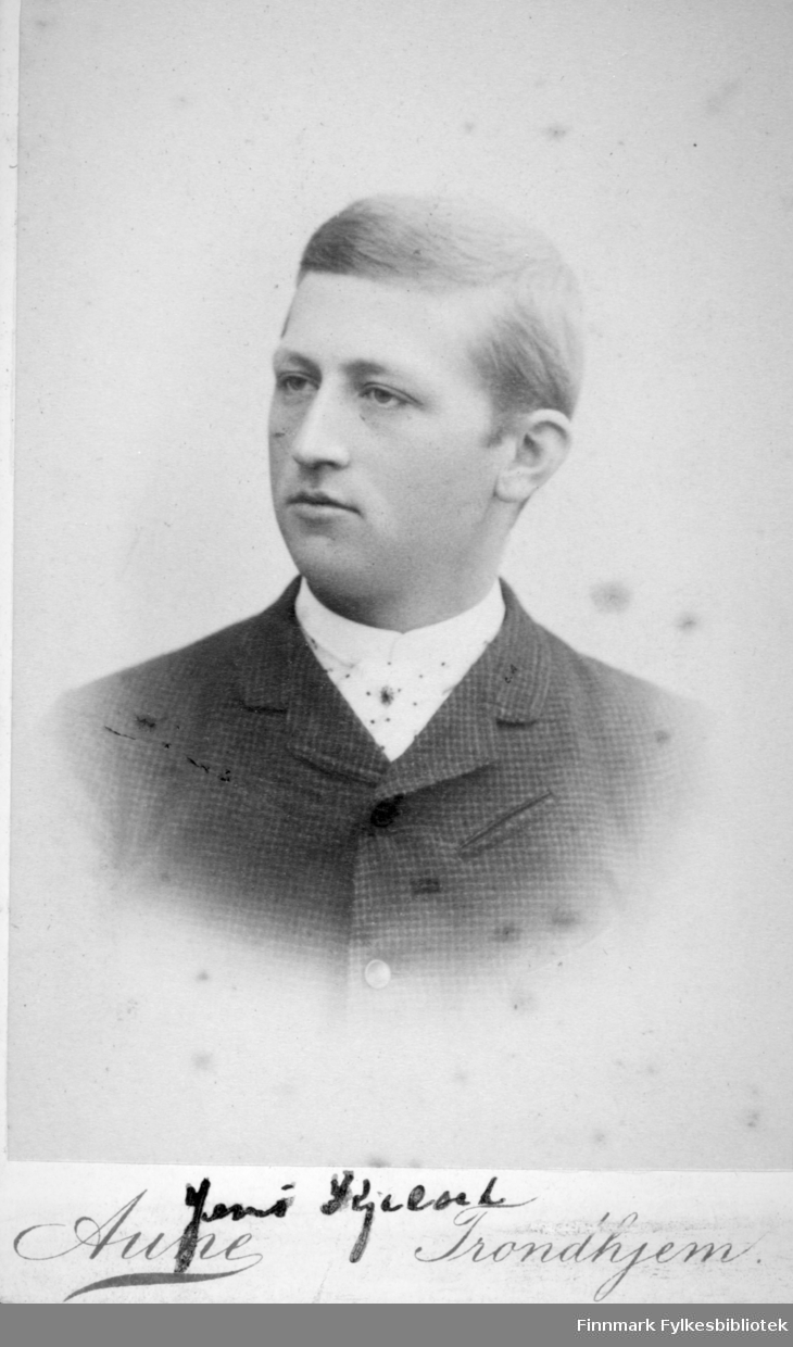 Portrett av en mann iført en mørk dressjakke og hvit skjorte