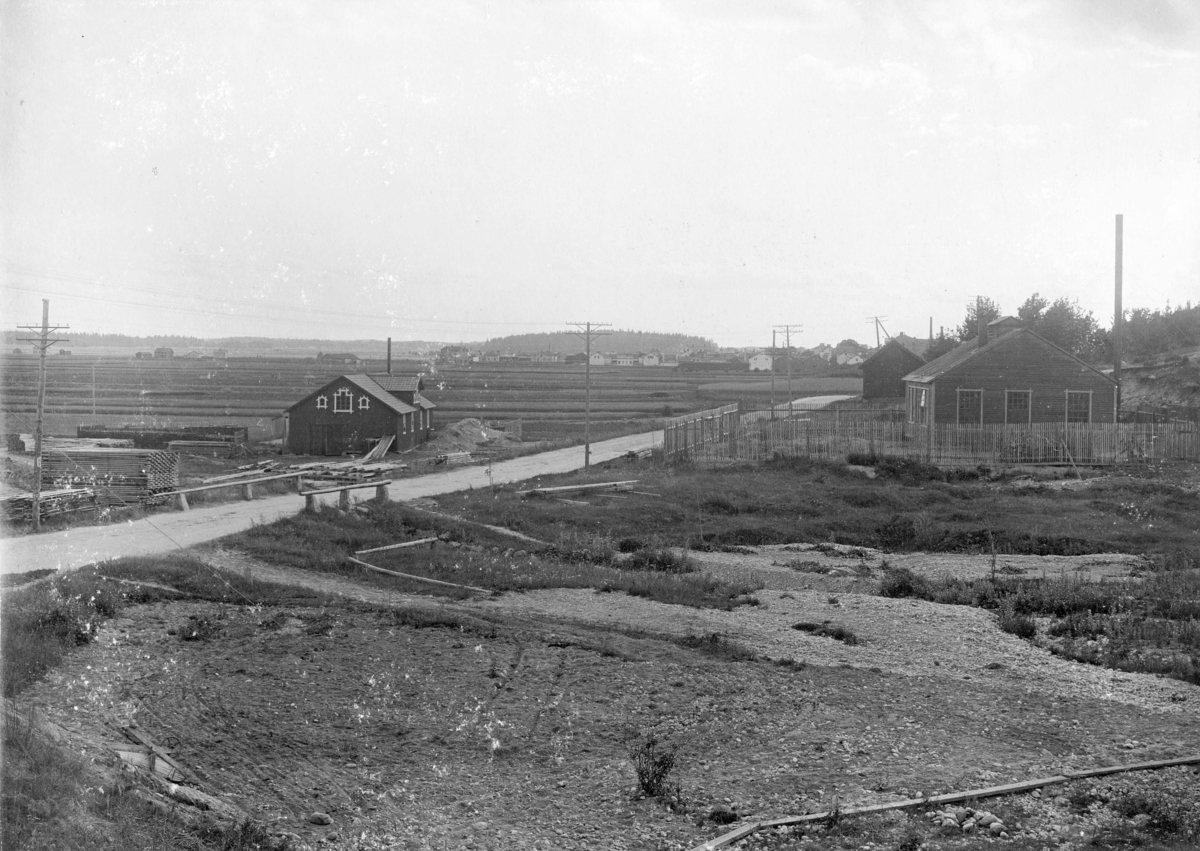 Stockholmsvägen med Skvalbron, nuvarande Fannakorset, Enköping, vy från norr, 1899-1900. T. v. Fanna ångsåg. T. h. Holmströms smedja.