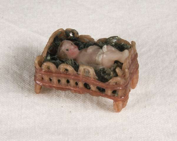 Baby i korg gjord av vax eller liknande.