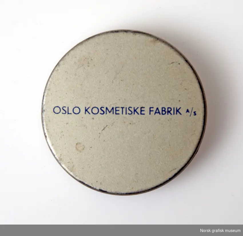 Rund blikkeske med lokk.
Farger: hvit (sølv?), blå
Merket: Ecko Spesial Creme OKF Oslo Kosmetiske Fabrik A/S