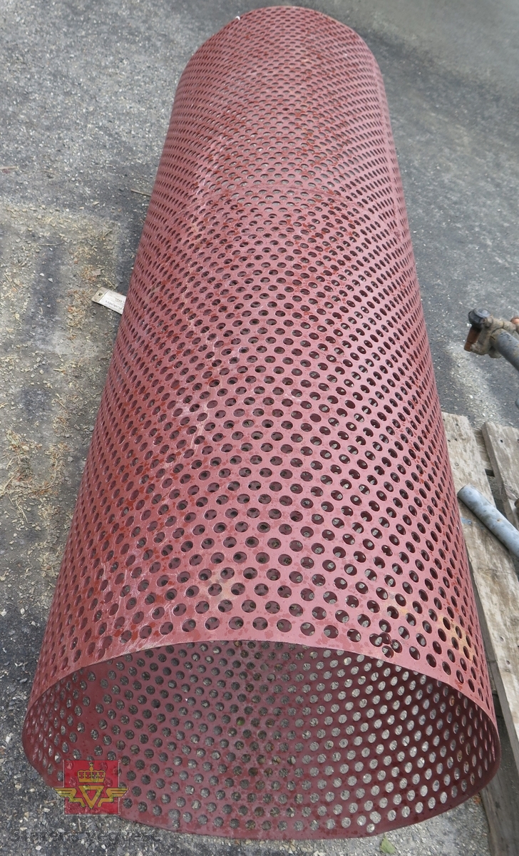 Sylindrisk sorteringstrommel, lagd av perforert (14 mm hull) stål/jernplate. Påført rød Coroless grunning (rustbeskytter). Trommelen mangler flenser i hver ende.