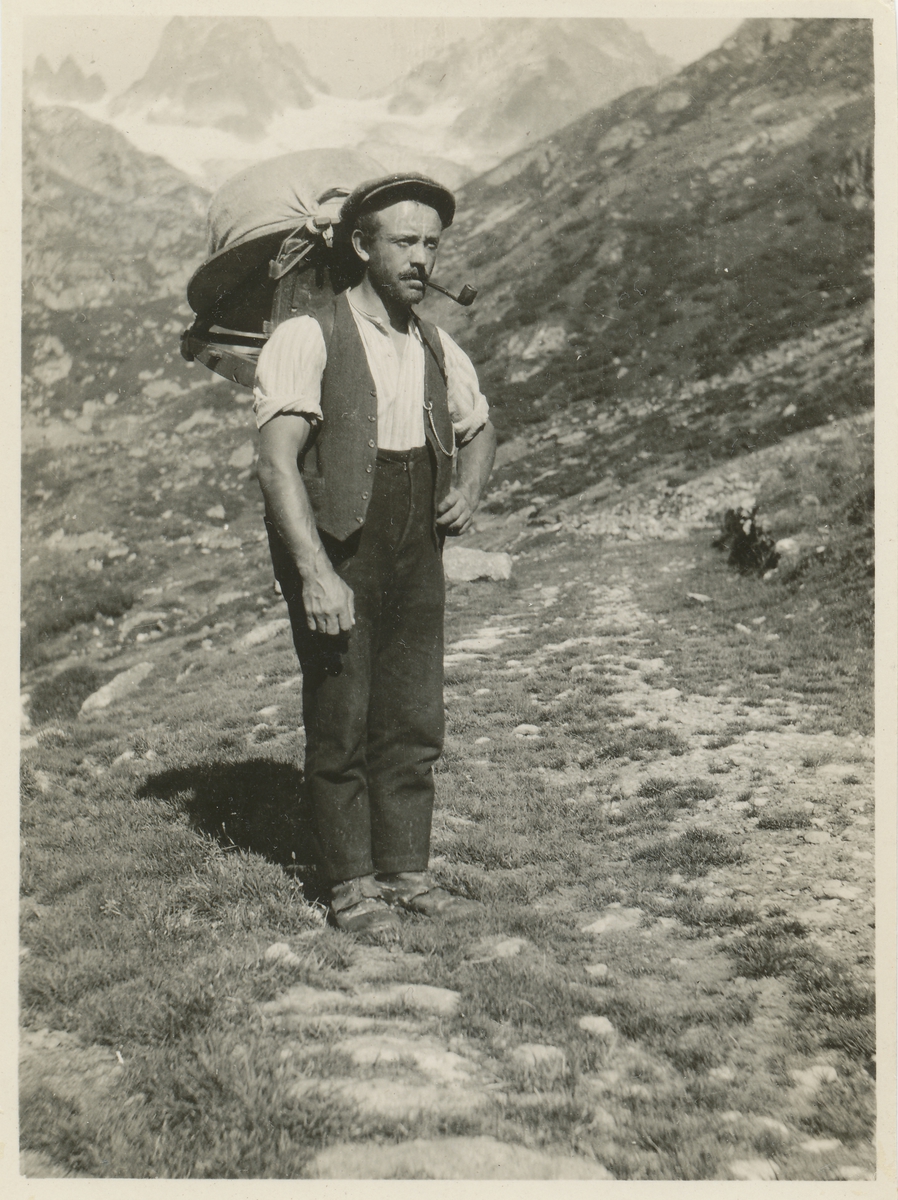 Mann med ryggsekk på fjelltur i Grønlandske fjell.