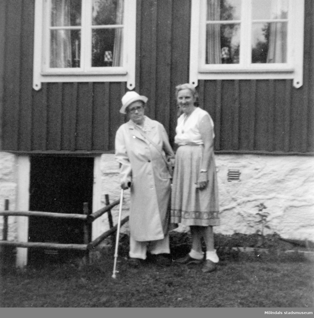 Anna "ve sjön" (Anna Johansson) står till vänster och Runa (kusinens fru) till höger. De står framför "Stugan" i Gunnebo. 1979.
