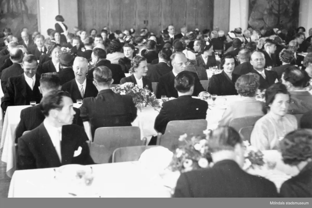 Flertalet människor som sitter vid uppdukade långbord i en stor lokal. 1940-tal.