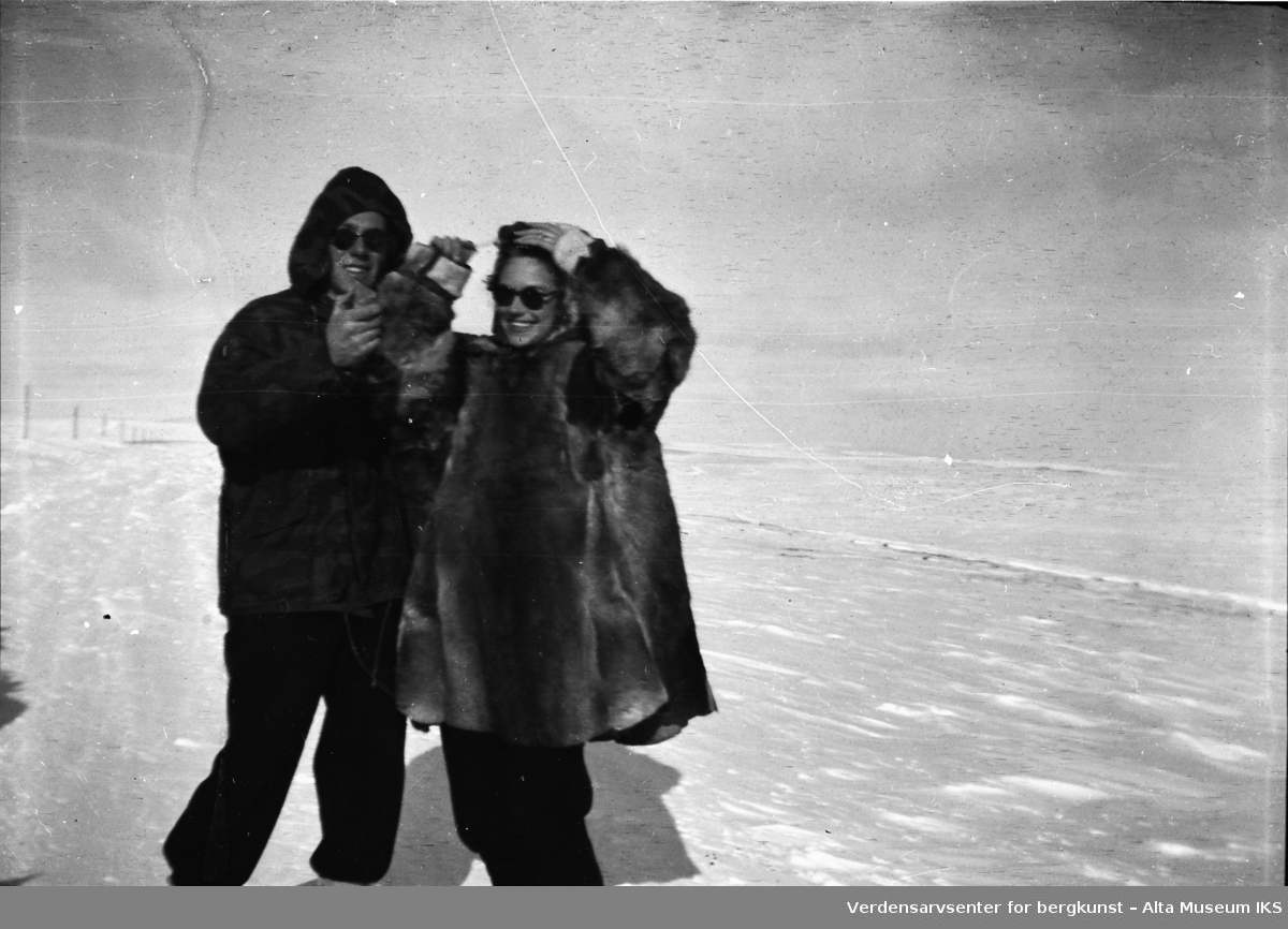 Per og Erna Jøraholmen står i vintersolen og smiler til kameraet. De er iført vinterklær, med et flatt og bart vinterlandskap bak dem.