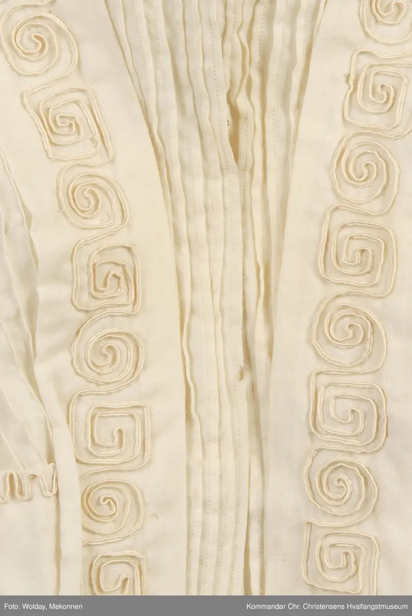 Teknikk: Håndarbeid. Sydd både for hånd og på maskin Høy krave av bomullsblonde. 3/4 lange ermer m/albulange overermer
