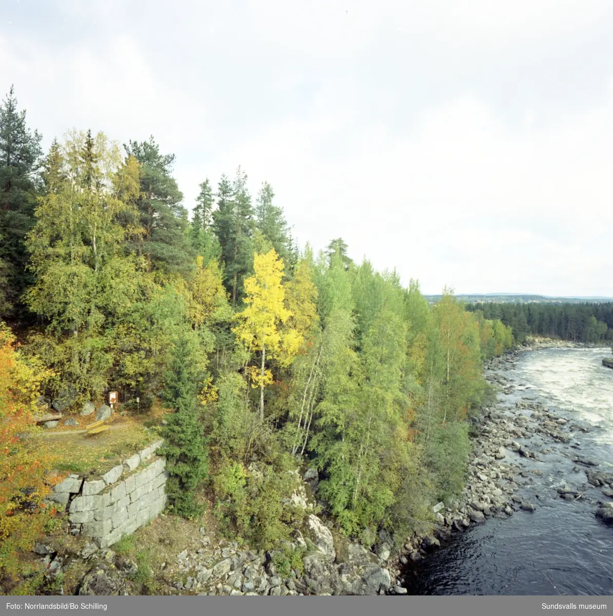 En stor grupp bilder från terrängen kring Ljungaverk hösten 1970. Landskapsbilder, vattendrag, olika byggnader med mera.