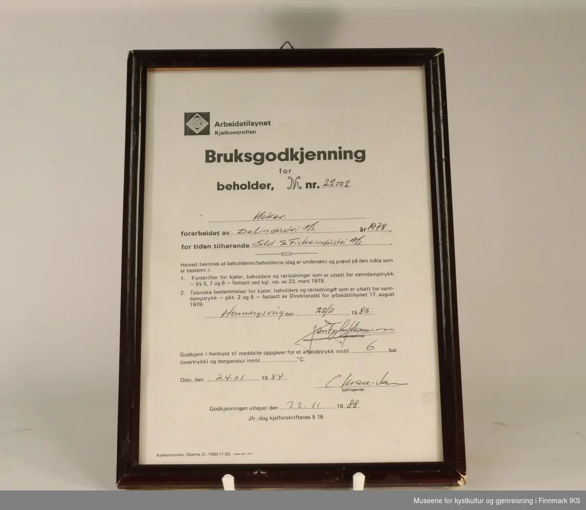 Bruksgodkjenning for koker (beholder nr. 22002) hos Sild & Fiskeindustri AS, utsendt av Arbeidstilsynet Kjelkontrollen i 1984. Hvitt papir med sort tekst. Utfylt for hånd. Innrammet.