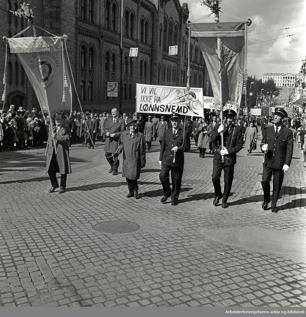 1. mai 1964 i Oslo.Demonstrasjonstoget i Karl Johans gate.Fane: Oslo Sporveisarbeideres Forening.Fane: Oslo Sporveis Betjenings Foorening.Parole: Vi vil ikke ha lønnsnemd