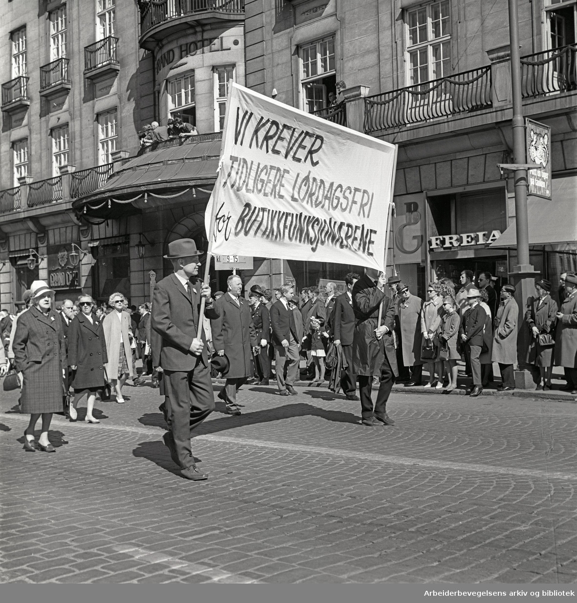 1. mai 1965 i Oslo.Demonstrasjonstoget i Karl Johans gate.Parole: Vi krever tidligere lørdagsfri for butikkfunksjonærene
