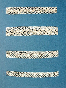 Blått kartongark med fyra prover på skånsk knyppling från östra Göinge. Vid varje prov står en stor bokstav.
A. 13x 1,7 cm
B. 13 x 2,2 cm
C. 13 x 1,7 cm
D. 13 x 1,3 cm
