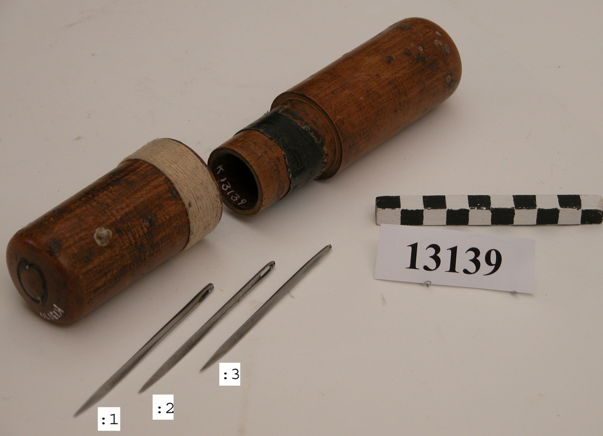 Nål för segelsömmare av stål. Nålen förvaras i cylindriskt fodral av trä med märkning: S.H. (Sten Hansson)