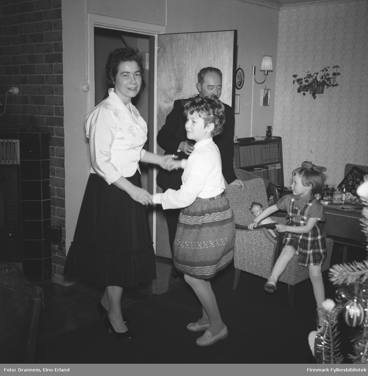 Mor og datter, Jenny og Turid Lillian danser, ved døra står Olav Sørensen, Grete Sørensen sitter i en lenestol. Det er juletid
