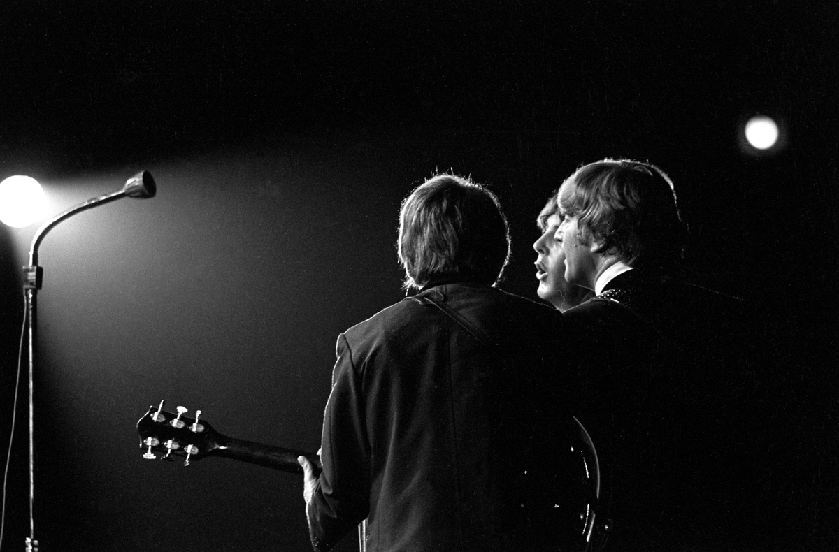 Konsert med det engelske bandet The Beatles i K.B. Hallen i København. På scenen John Lennon nærmest, George Harrison og Paul McCartney.