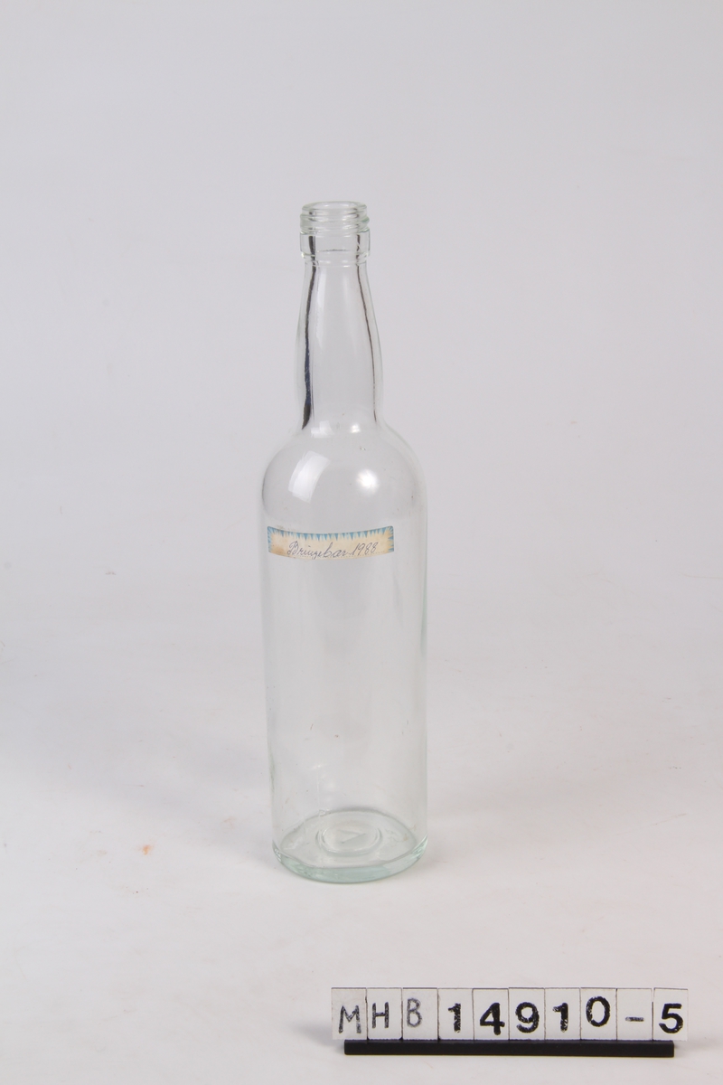 Glassflaske med etikett. Brukt til oppbevaring av Bringebærsaft.