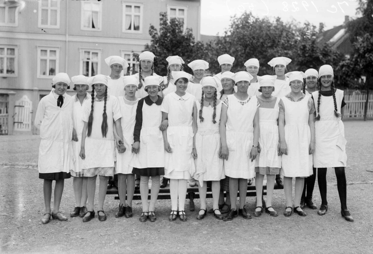 Klassebilde. 7e 1928. Piker i skolekjøkkenantrekk.
