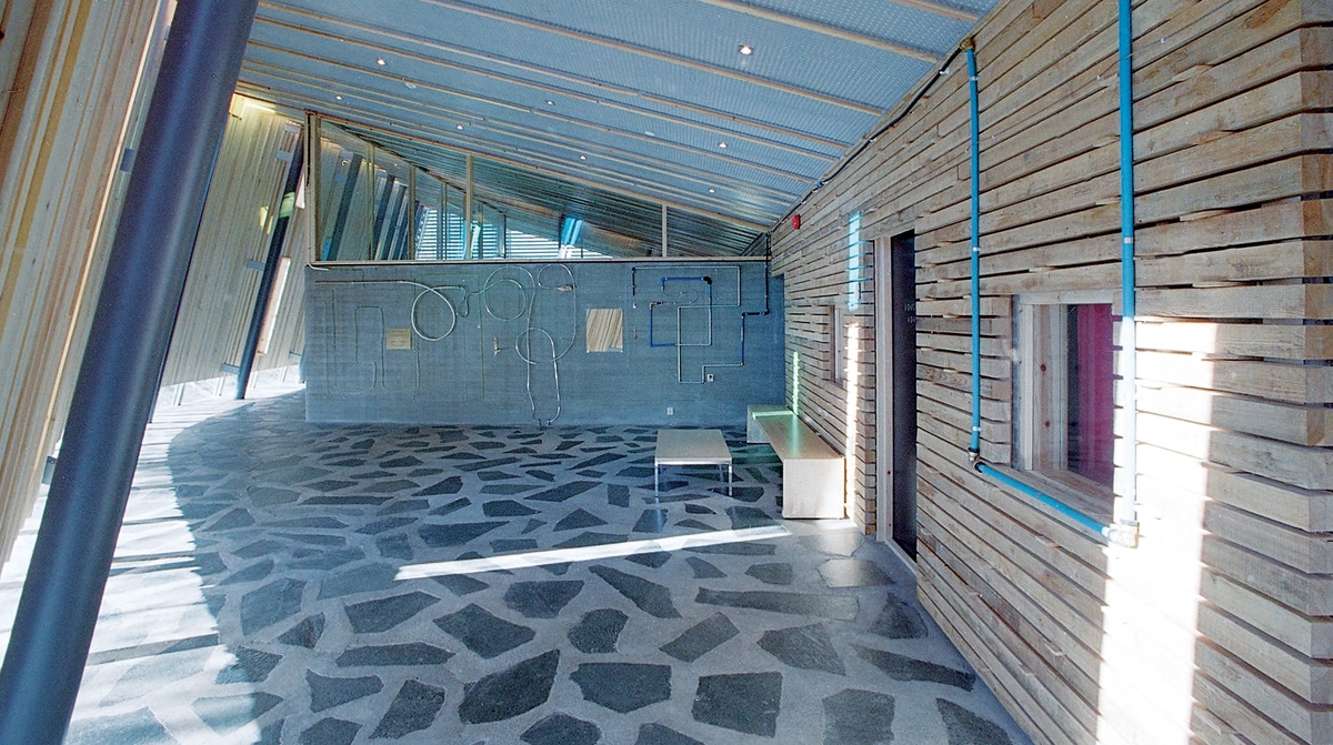 Elementene i installasjonen utgjør et tegnet mønster som assosierer både til et industrielt scenario og til labyrinten, uten at det umiddelbart lar seg entydig gripe. Flere steder er rør malt blå, gule og grønne, som reflekterer lyset som sprer seg øverst i rommet gjennom de tilsvarende fargede vindusglassene. Dette bidrar til å skape en estetisk og poetisk dialog mellom kunsten og bygget. På betongveggen finner man spredte hverdagsgjenstander slik som et speil, et forseggjort messingdørhåndtak, en stikkontakt, samt elementer fra naturen i form av et vakkert sammenfoldet skjell, bambus og trestykker. Fra fondveggen strekker installasjonen seg videre i ulike retninger bortover langs de tilstøtende veggene og avsluttes på forskjellig vis, som for eksempel i kunstnerens personlige pilspiss, godt bevart fra egen barndom. En av linjene bryter tvers gjennom bygningsveggen og fortsetter videre i utomhusterrenget i det utvendige inngangspartiet. Der løper den langs bakken, kryper oppover en stor granittstein som kunstneren har hentet fra den lokale elvebredden og videre langs bakken, for til sist å forsvinne ned i jorden.

En messingplate til venstre på fondveggen har det indianske ordtaket «Det er syv hovedretninger: Opp, Øst, Sør, Nord, Vest, Ned og Inn i Deg Selv» innrisset på samisk og norsk som gir oss et utgangspunkt for egne tolkninger. Linjene i installasjonen har noe med retningene å gjøre for de ulike gjenstandene er metaforer. I speilet møter du deg selv, og med håndtaket kan du åpne dører og grenser. Pilen peker mot skogene som symboliserer en del av menneskenes naturlige røtter, vår fruktbarhet er knyttet til jorden og steinen er det eviges symbol.