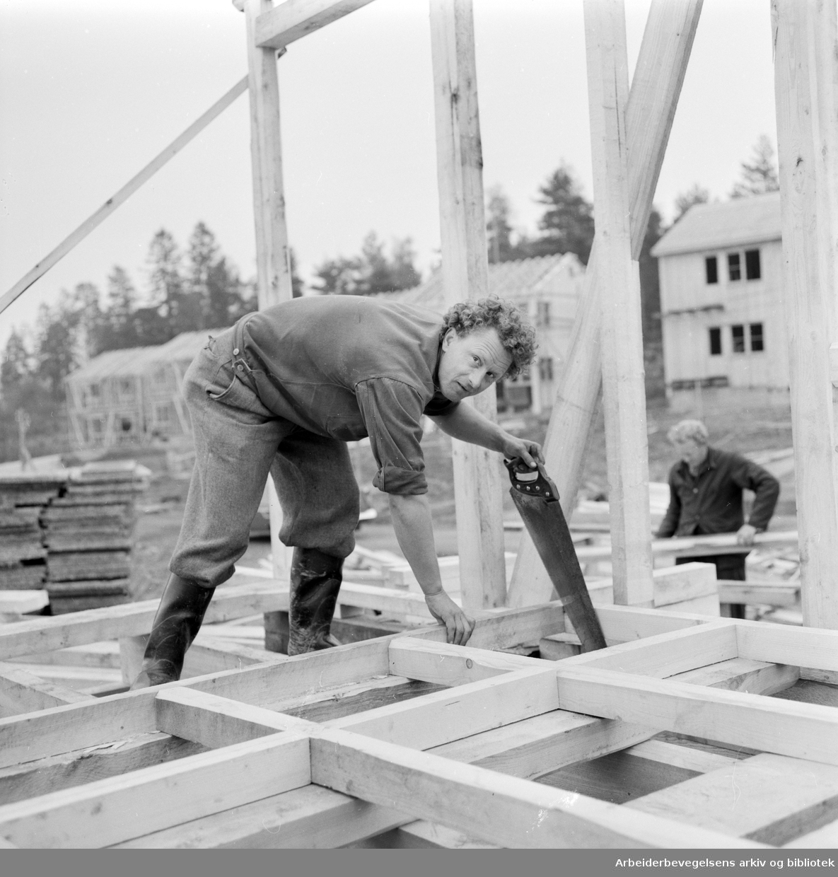 Tømmermann Kåre Sven Hansen i arbeid med reisverket på et av OBOS' småhus på Manglerud i Oslo. November 1958.