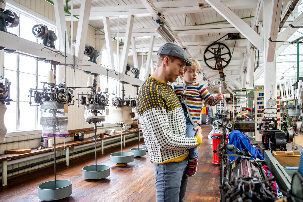man and child in a former textile mill with knitting machines