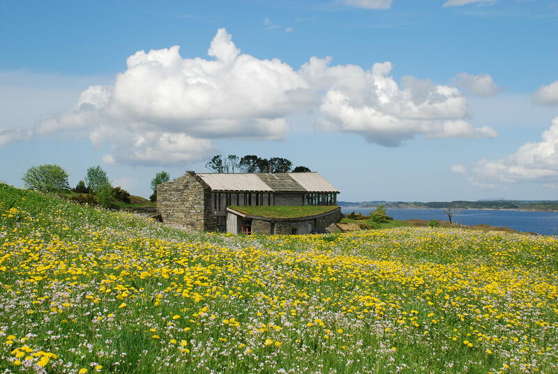Bygning i idyllisk landskap med blomstereng, Lyngheisenteret på Lygra (Foto/Photo)