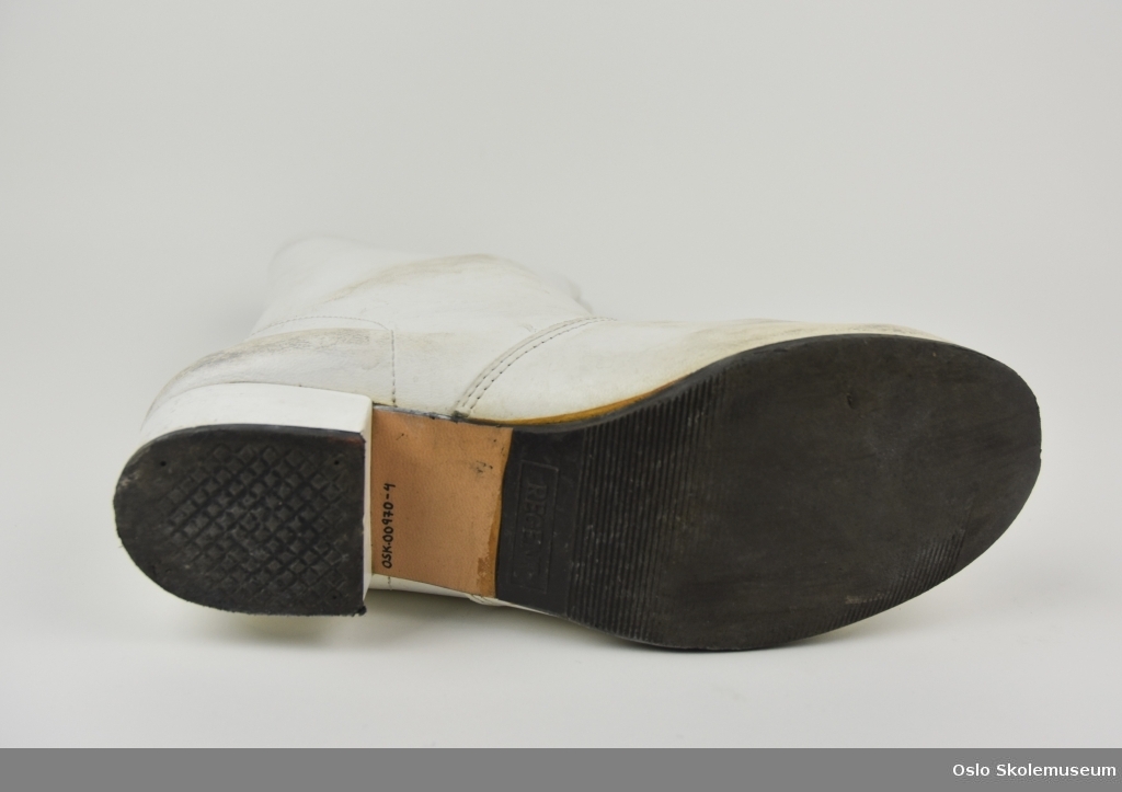 Et par hvite støvletter fra Lambertseter skoles musikkorps til barn. Støvlettene har svarte og brune såler.