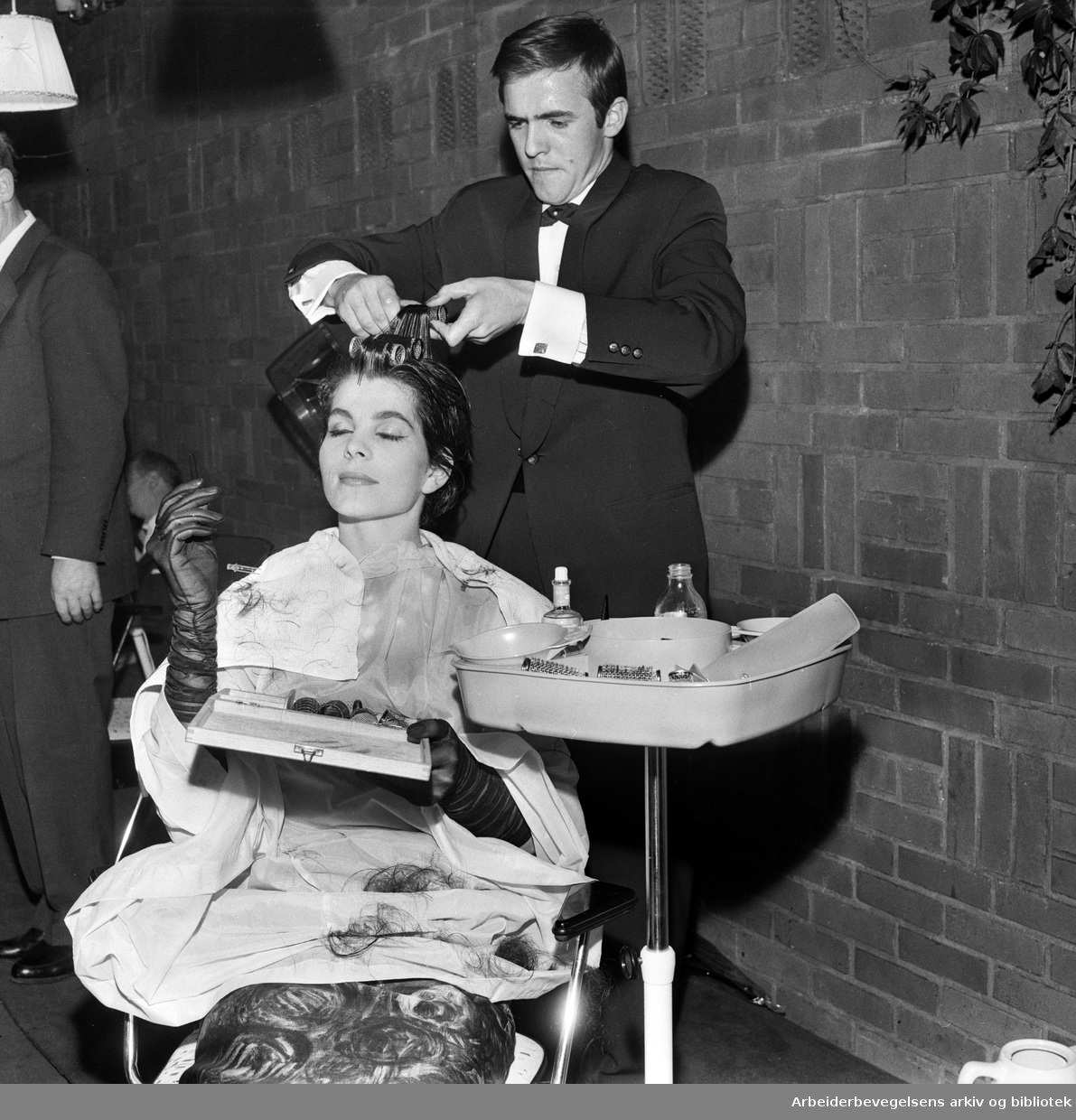 Den tyske frisøren Bernd Pawlowski lager en "Jackie-frisyre" på en modell under et arrangement i Ingeniørenes Hus. September 1961.